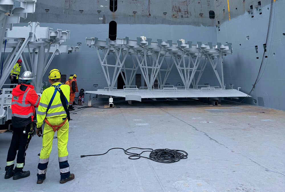 Workers loading telescope components on cargo ship